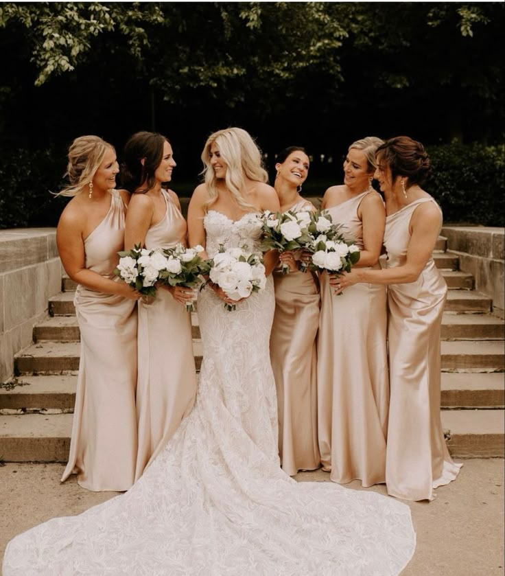 a group of women standing next to each other in front of some stairs with flowers