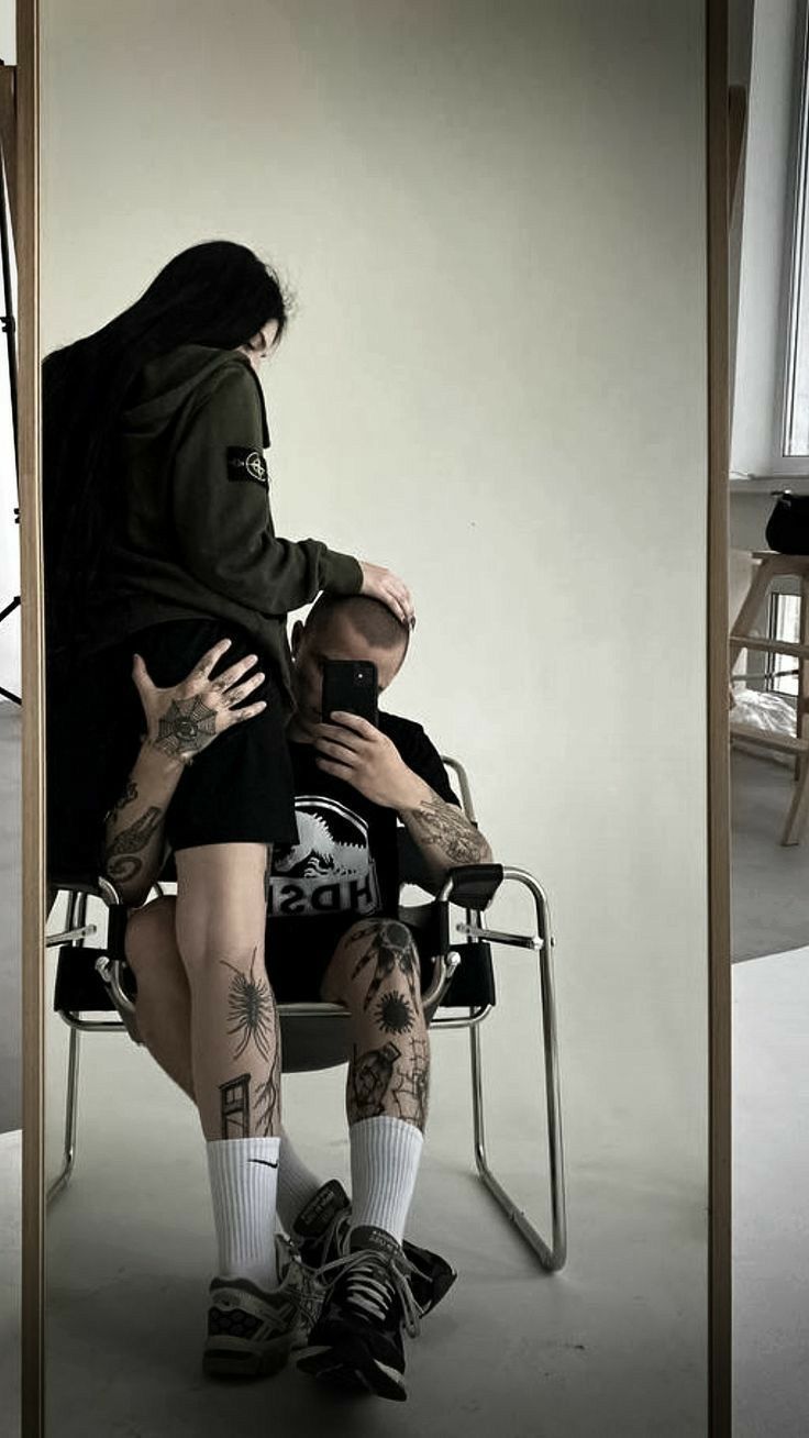 a man sitting in a chair with his arm wrapped around another man's leg