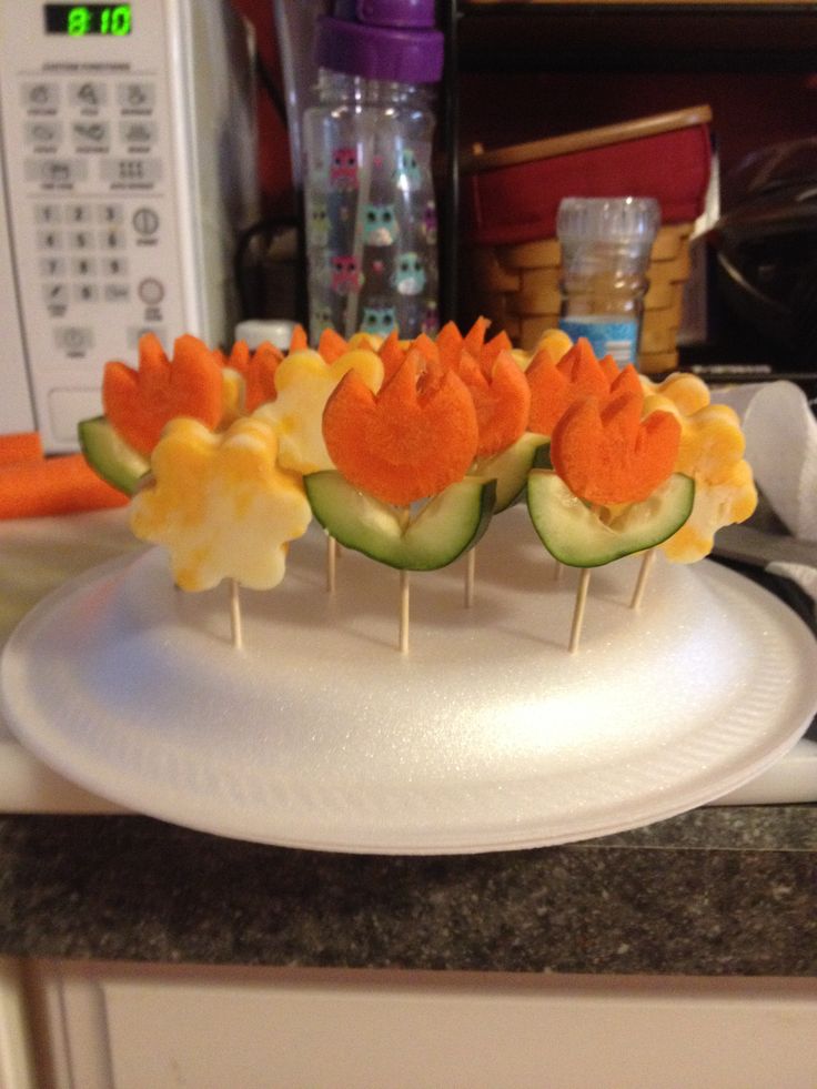 several appetizers are arranged on a plate with toothpicks in the shape of flowers