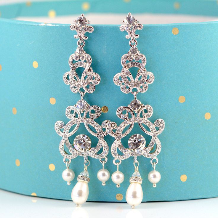 "These glamorous Wedding Bridal Chandelier Earrings feature vintage style Rhinestone components (rhodium plated) encrusted with lots of Swarovski crystals. Accented with Swarovski teardrop pearls, rhinestone drop charms and tiny Swarovski crystals to give a glamorous look. These are 3 1/2\" long and 1 1/4\" (28mm) wide at widest point. These earrings have an exquisite sparkle and are a perfect Wedding accessory. They would also make a glamorous statement to an evening and cocktail party wear! Ma Silver Chandelier Earrings With Rhinestones For Anniversary, Silver Crystal Chandelier Earrings With Elegant Design, Silver Chandelier Earrings With Elegant Crystal Design, Glamorous Silver Pearl Drop Bridal Earrings, Glamorous Silver Bridal Earrings With Pearl Drop, Ornate Silver Chandelier Earrings With Pearl Drop, Glamorous Silver Pearl Earrings For Wedding, Wedding Bridal Earrings With Rhinestones And Dangle Shape, Vintage Crystal Chandelier Earrings For Wedding