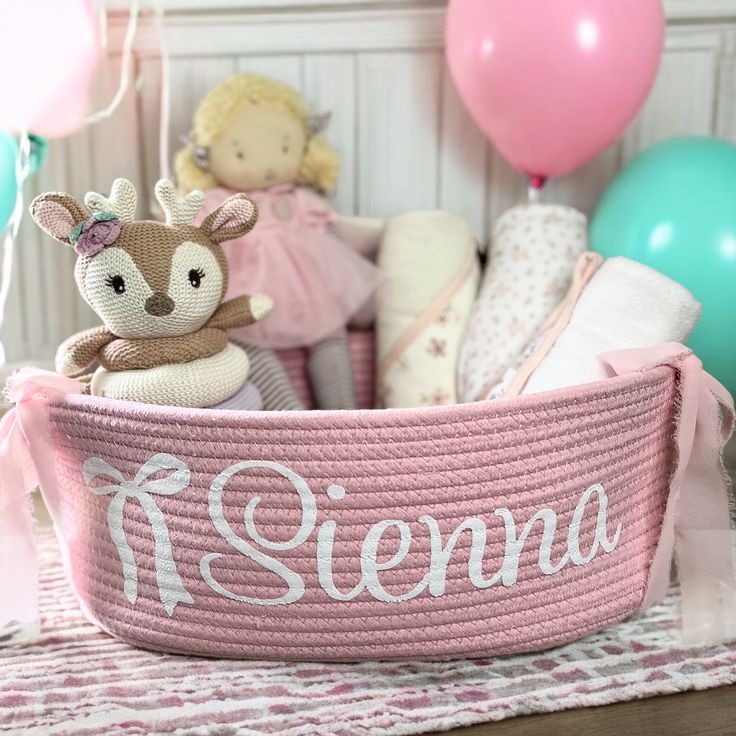 a stuffed animal in a pink knitted basket with the name stena on it