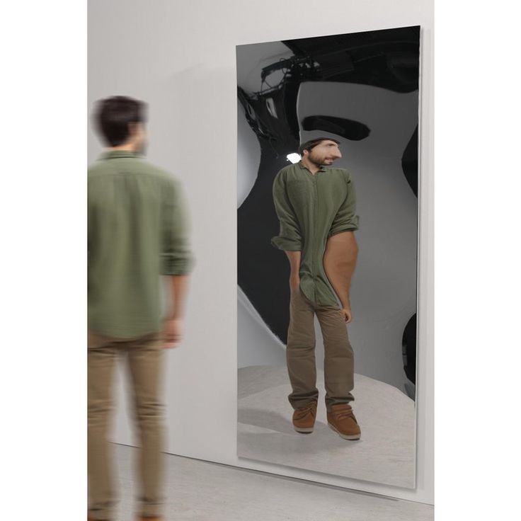 a man standing in front of a mirror with an apple logo on it's side