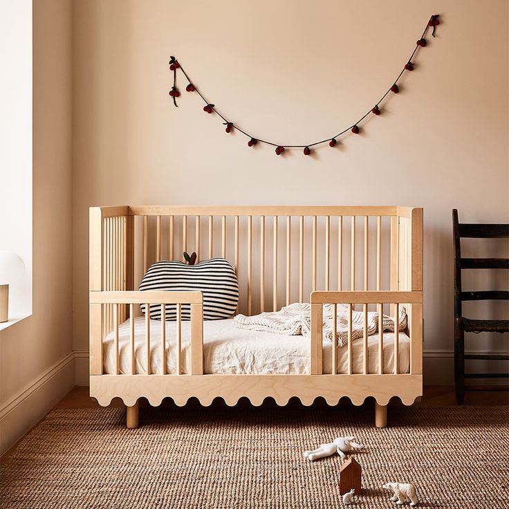 a baby's crib in the corner of a room with toys on the floor