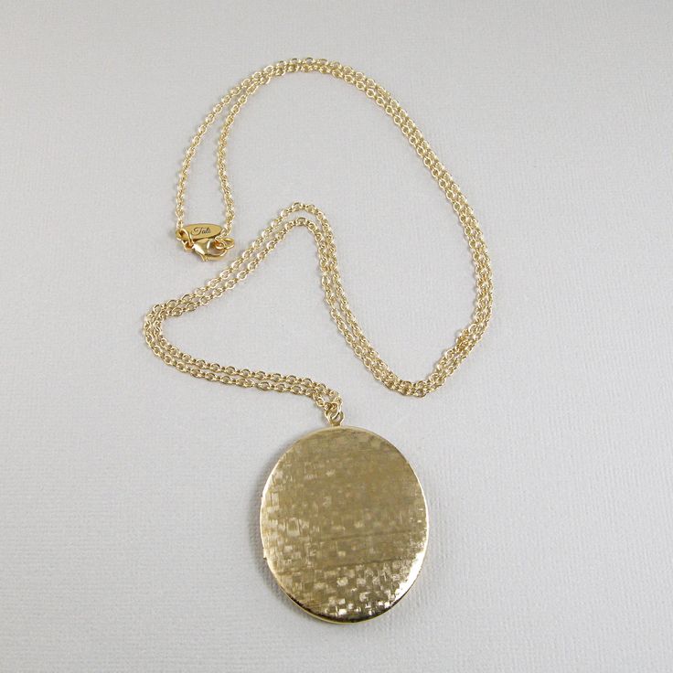 Keep pictures of your loved ones close to your heart with this lovely textured oval photo locket necklace. The necklace is made with a large textured gold plate oval shaped photo locket that is suspended on 14k gold filled chain and 14k gold filled lobster clasp. This locket is larger than the average photo locket. The average photo locket size is 3/4th of an inch or smaller. This locket is an inch and three quarters long (1.75”) and one and a half inch wide (1.5”).Available in six necklace leng Oval Pendant Locket Necklace With Adjustable Chain For Keepsake, Gold Oval Link Locket Necklace For Anniversary, Gold Oval Locket Necklace For Keepsake, Gold Oval Pendant Locket Necklace For Keepsake, Gold Oval Pendant Locket Necklace, Personalized Gold Locket Necklace With Oval Pendant, Gold Oval Pendant Locket Necklace Gift, Gold Oval Keepsake Necklace, Oval Gold Keepsake Necklace