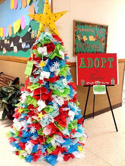 a brightly colored christmas tree in the middle of a room with colorful streamers hanging from it's sides