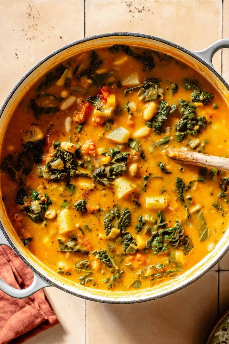 a pot filled with soup and vegetables on top of a table