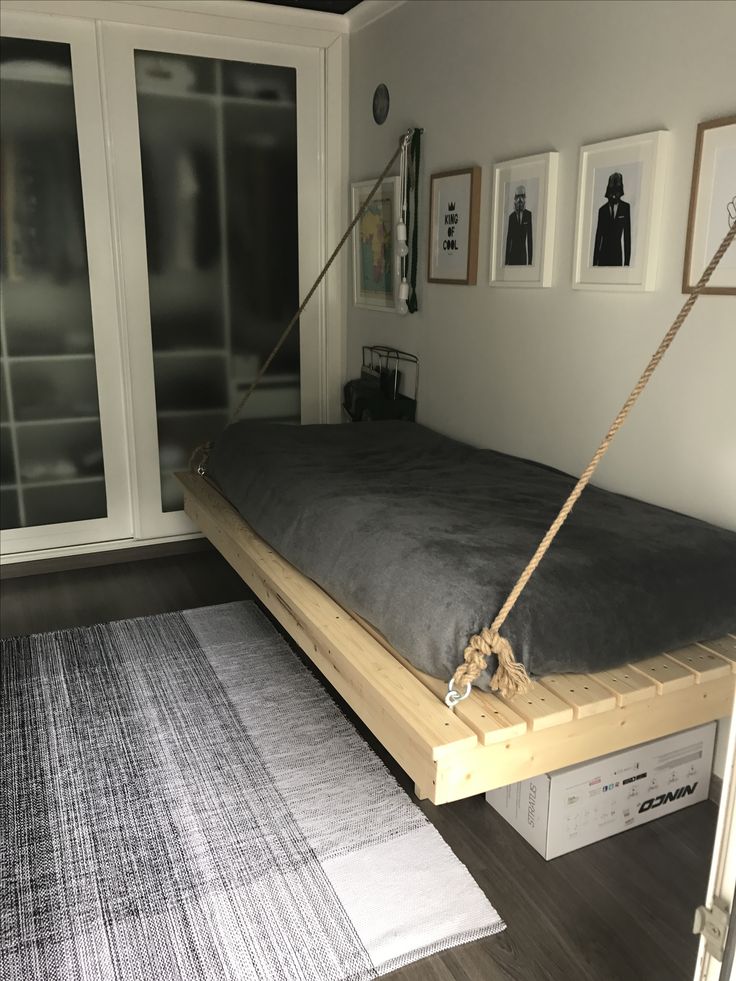 a bed that is sitting on top of a wooden platform with rope attached to it