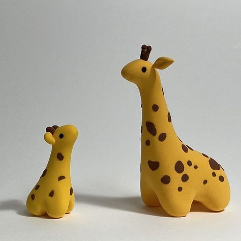 two giraffes sitting next to each other on a white surface