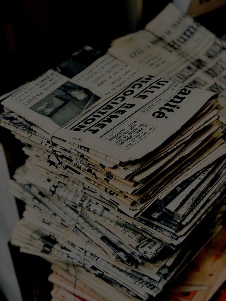 a stack of newspapers sitting on top of a table