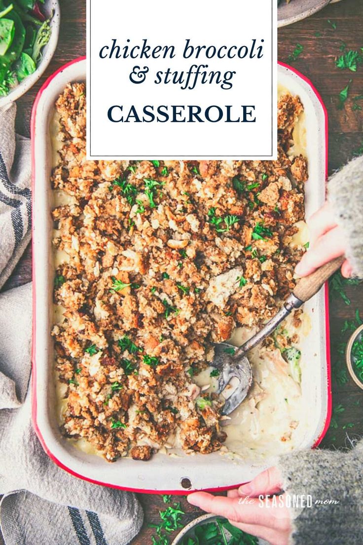 chicken broccoli and stuffing casserole in a red dish with a serving spoon