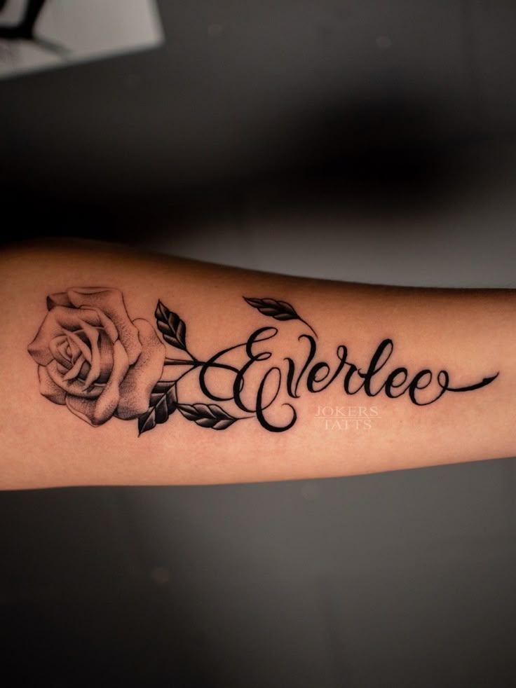 an arm with a rose and the word everless written in cursive writing