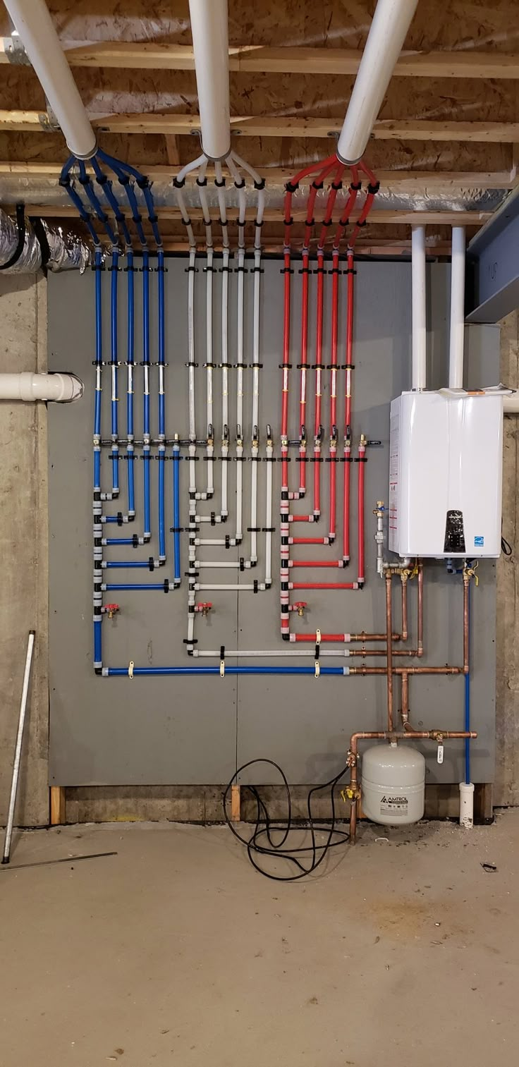 pipes and water heater in an unfinished room