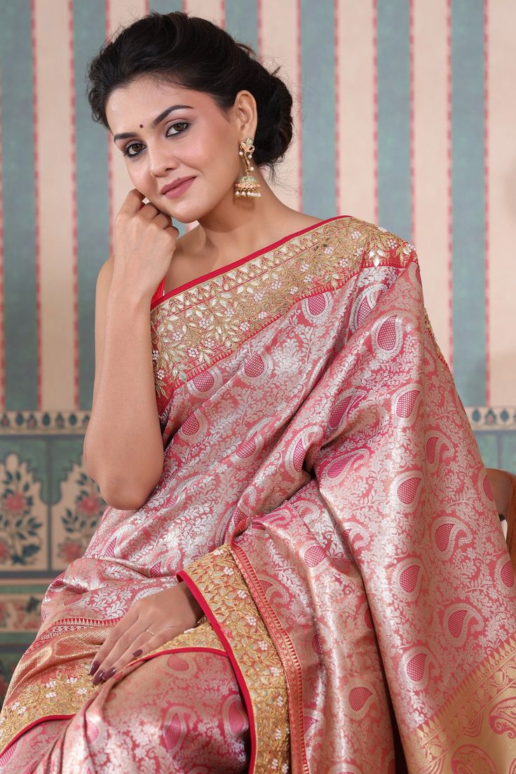 Beautiful pink Banarasi silk saree with gota work border is a perfect drape for festive occasions! It comes with a blouse piece. Disclaimer: The actual product may vary slightly from the image. These are custom orders, hence expect slight variation in color, placement of the motif or buta. ESTIMATED DELIVERYBecause this is a custom order, it would take about 4 weeks from the date of purchase. RETURN POLICYThis product is a custom order and cannot be returned or exchanged.