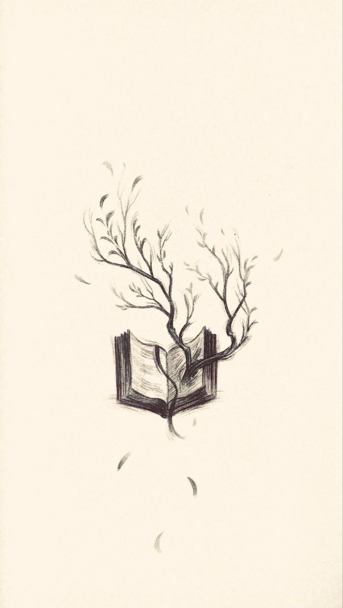 an open book sitting on top of a table next to a tree with branches growing out of it