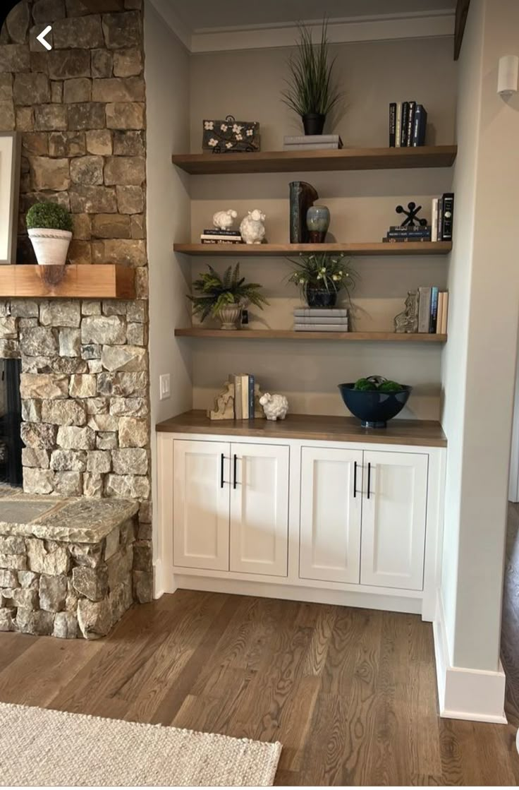 a living room filled with furniture and a fire place in front of a stone fireplace