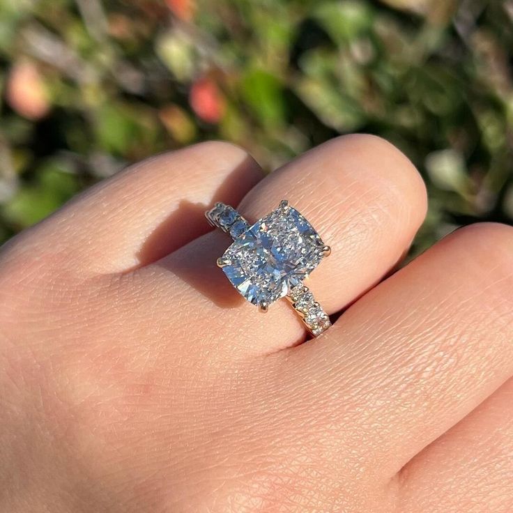 a woman's hand with a ring on it that has two stones in the middle