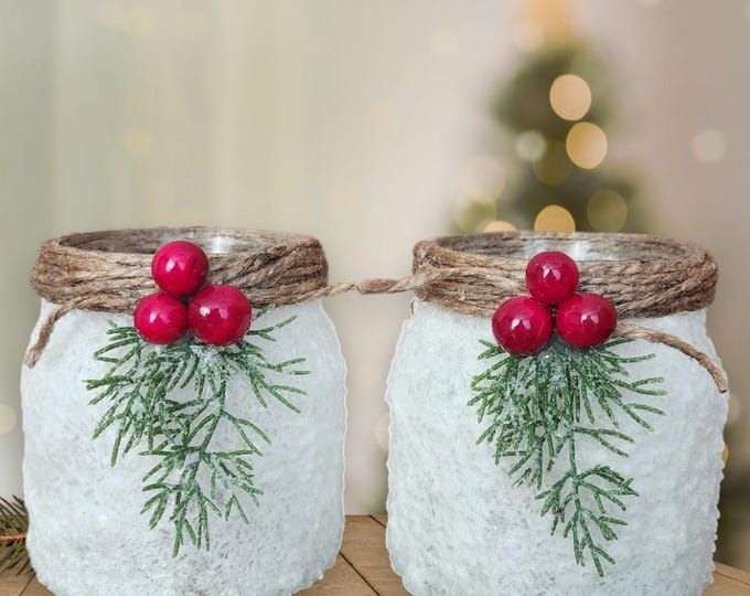 two mason jars decorated with christmas decorations