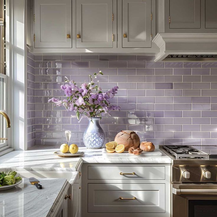 a vase filled with purple flowers sitting on top of a counter next to a stove