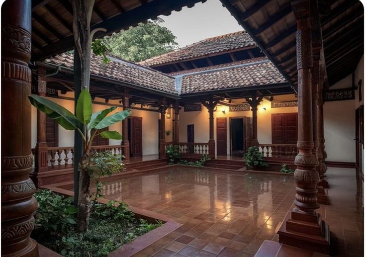 the inside of a house with tiled flooring and wooden pillars on either side of it