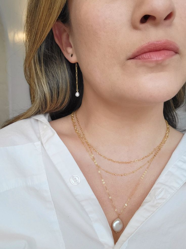 These Pearl and 14K Gold Filled chain earrings are delicate and minimal! The dainty gold paperclip chain attaches to the back of each stud and creates a gorgeous modern look. Prepare to get tons of compliments on these earrings! * 14K Gold Filled circle studs and chain * 2.25" length * 6mm slightly irregular Freshwater Pearls * Made with all hypoallergenic materials 🤍 *Please note for the health and safety of my customers, and to uphold the highest quality standards - these earrings are final s Delicate Yellow Gold Threader Earrings, Minimalist Gold-plated Earrings With Delicate Chain, Dainty Teardrop Earrings With Delicate Chain, Minimalist Gold Plated Earrings With Delicate Chain, Minimalist 14k Gold-filled Earrings With Delicate Chain, Delicate Gold-plated Chain Earrings, Dainty Gold Hypoallergenic Threader Earrings, Gold-plated Delicate Chain Earrings, Dainty Drop Earrings With Delicate Chain