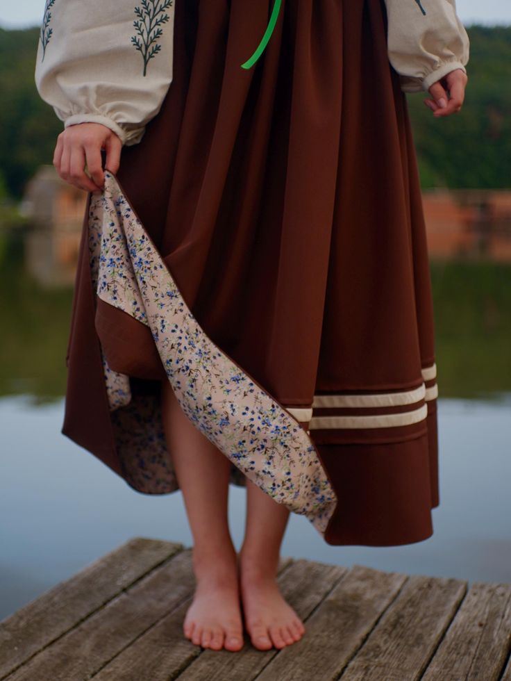 Embrace timeless elegance with our handcrafted skirt, featuring a rich brown fabric with a delicate floral lining that adds a touch of softness. Paired with intricate embroidery on the sleeves, this piece captures the essence of nature and tradition. Perfect for those who appreciate vintage-inspired, artisanal fashion. 🌿 Enter your waist size and height when ordering and we will sew it perfectly for you! Brown Lined Tiered Skirt, Brown Tiered Lined Skirt, Vintage Brown Flowy Skirt, Brown Pleated Tiered Skirt, Brown Gathered Long Skirt, Brown Long Gathered Skirt, Elegant Brown Tiered Skirt, Brown Vintage Tiered Skirt, Vintage Brown Tiered Skirt