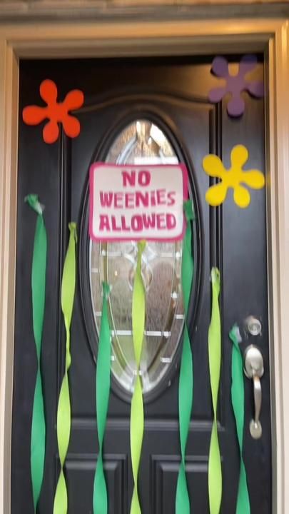 a door decorated with paper flowers and no weenies allowed sign