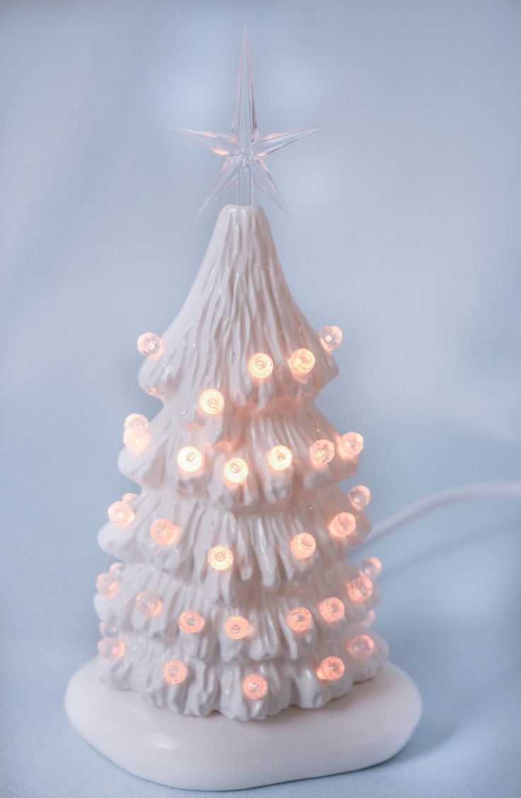 a small white christmas tree with lights on it