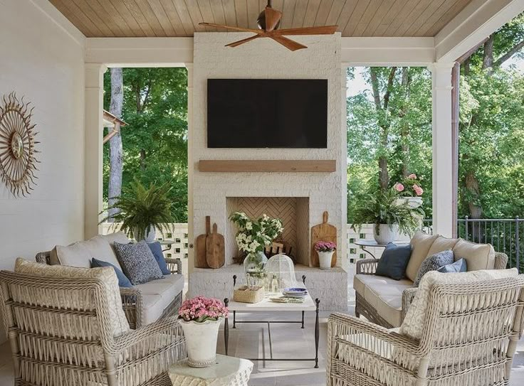 a living room with wicker furniture and a flat screen tv mounted on the wall