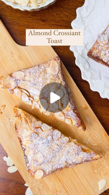 two slices of almond croissant toast on a cutting board next to another plate