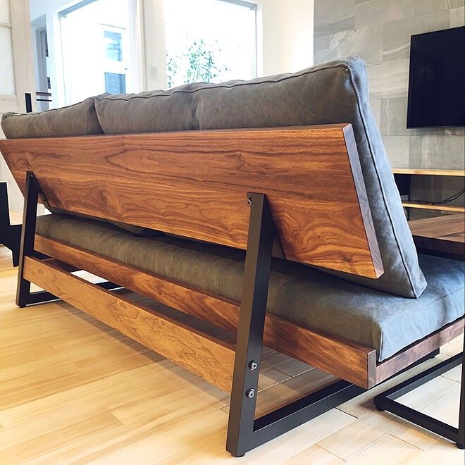 a wooden bench sitting on top of a hard wood floor next to a tv monitor