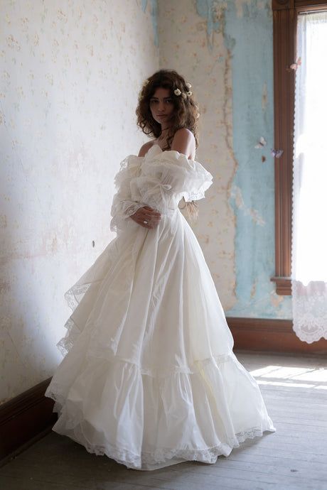 a woman in a white dress is posing for the camera