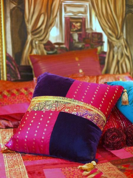 a bed covered in lots of colorful pillows