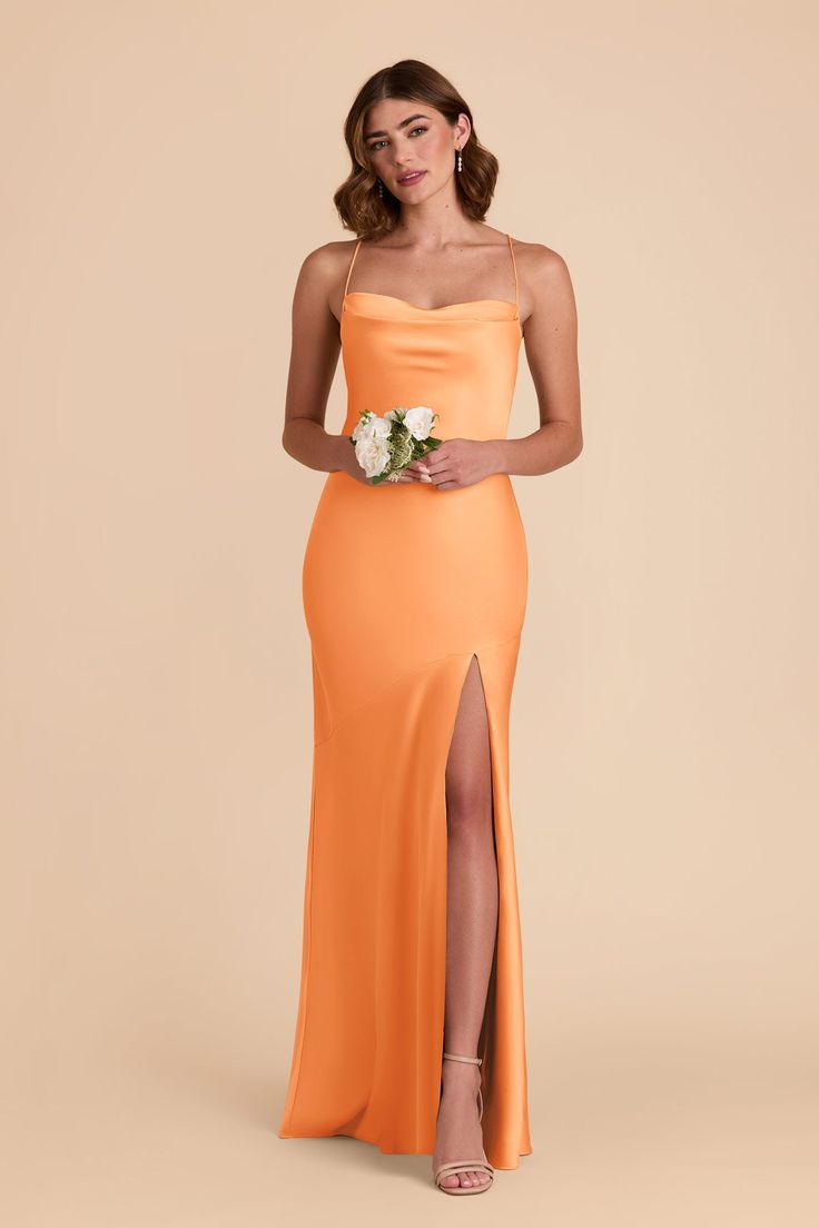 a woman in an orange dress holding a bouquet