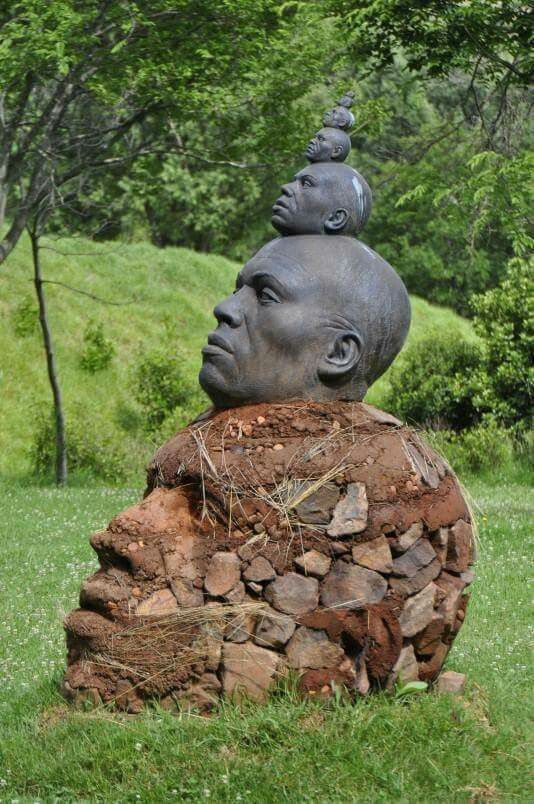 a sculpture of a man's head sitting on top of a pile of rocks