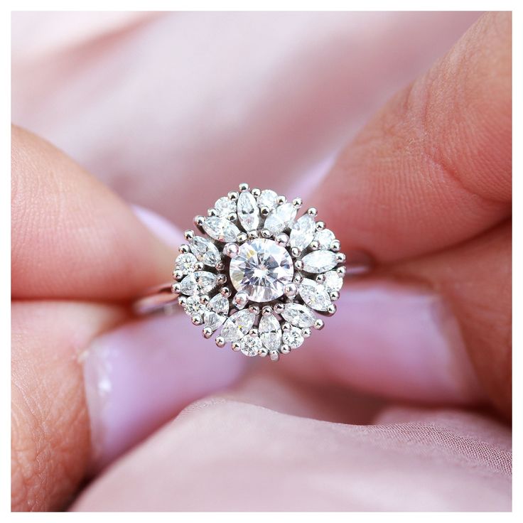 a close up of a person holding a ring with diamonds in it's center