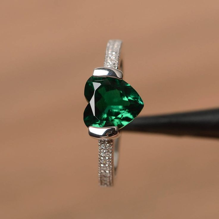 It is a lab emerald ring. The main stone is 8mm*8mm heart cut, weight about 1.59 carats. The basic metal is sterling silver and plated with rhodium. To change the metal to a solid gold (white/rose) or platinum is also available, please ask for a quotation if you want. You can also go to my shop Home for more elegant rings: https://www.etsy.com/shop/godjewelry?ref=hdr_shop_menu More emerald rings: https://www.etsy.com/shop/godjewelry/items?ref=seller-platform-mcnav&section_id=20709240 Customi Elegant Green Heart Promise Ring, Elegant Green Heart Sterling Silver Ring, Elegant Green Sterling Silver Heart Ring, Green Heart Ring For Wedding And May Birthstone, Green Heart Ring For May Birthstone, Green Heart Ring For May Birthstone Wedding, Green Heart Ring For Wedding With May Birthstone, Green Heart Ring For Wedding, May Birthstone, Fine Jewelry Green Heart Ring For May Birthstone