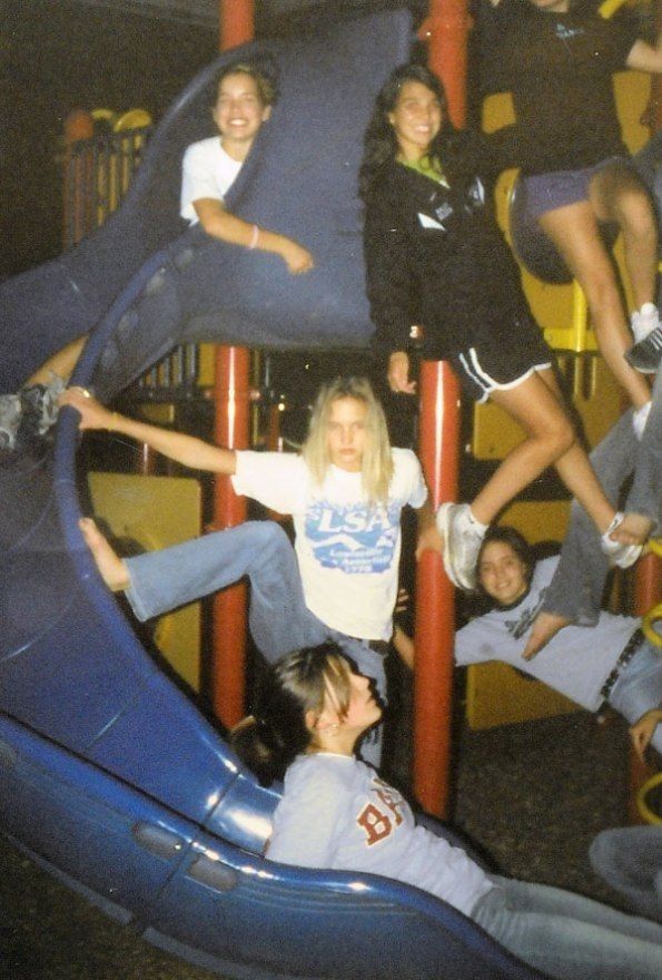 a group of people sitting on top of a blue slide