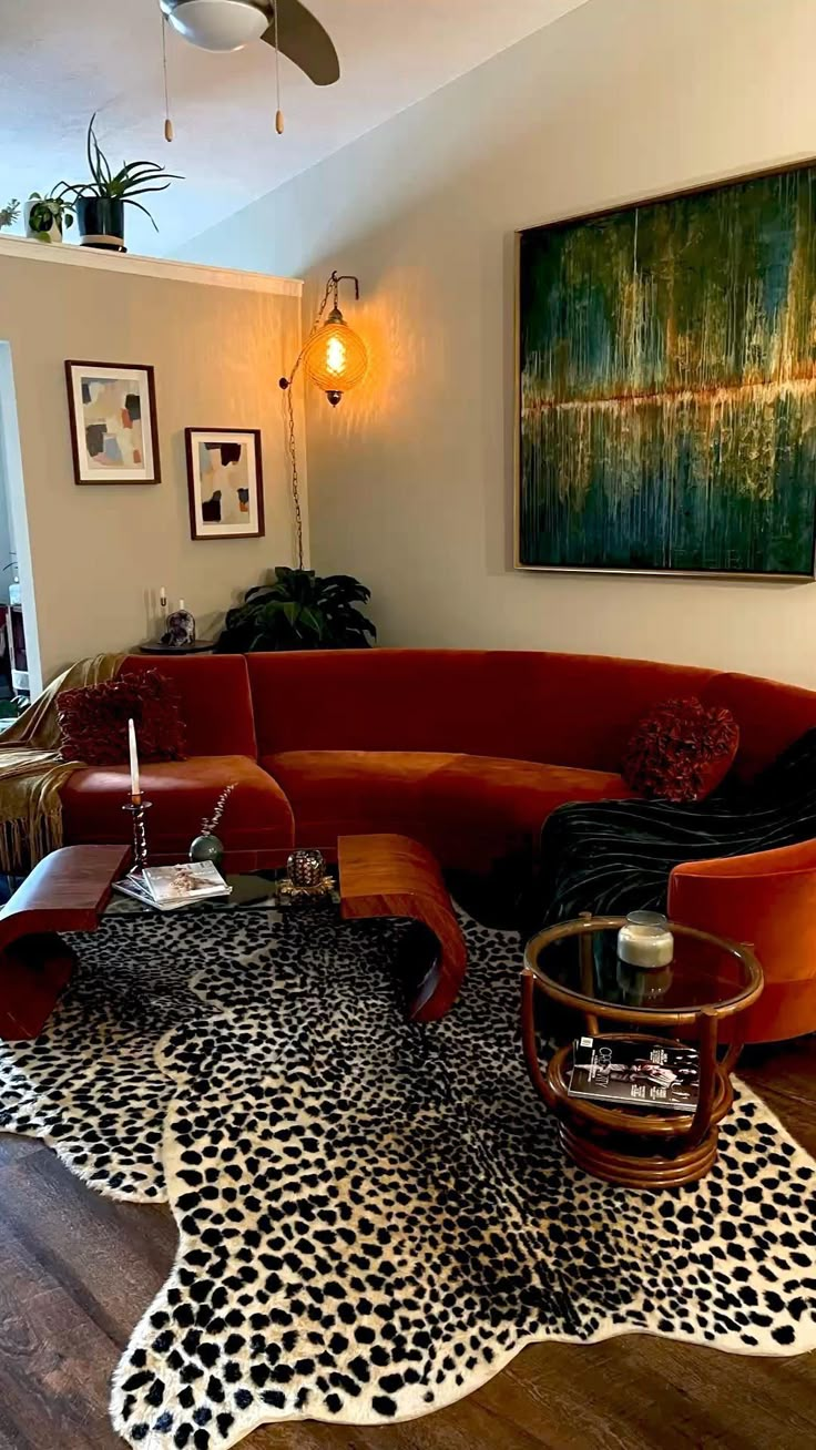 a living room with an animal print rug on the floor and a red sectional couch