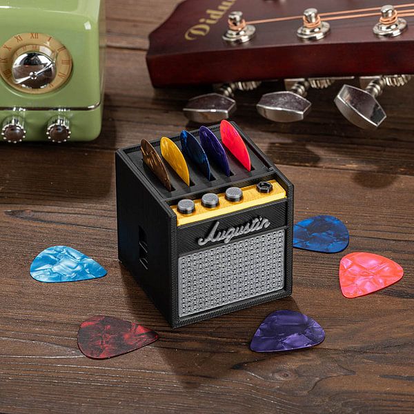 an electric guitar picker with several different colored picks on the ground next to it