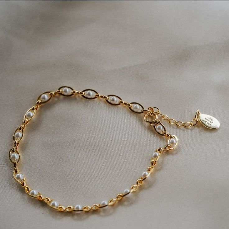 Our Pippa Pearl Bracelet is dainty + modern! What do we love about it? The tiny pearl accents add just a touch of traditional style in a modern way! This bracelet is perfect for any bridal event but can also be worn any time of the year or for any occasion which makes this the perfect gift! BRACELET FEATURES Materials: Brass, 14K Gold, Rhodium, Faux Pearl Finish: Choice of Yellow Gold or Rhodium Plating Dimensions: 6.5" with a 2" extender (can be worn up to 8.5") 14K gold-filled or sterling silv Elegant Metal Chain Bracelet With Pearl, Dainty Pearl Charm Bracelet Adjustable, Pearl Embellished Bracelet Jewelry Gift, Gift Pearl Embellished Jewelry Bracelet, Pearl Embellished Jewelry Bracelet Gift, Elegant Metal Bracelets With Pearl Chain, Elegant Metal Bracelet With Pearl Chain, Elegant Metal Pearl Bracelet As Gift, Pearl Chain Bracelet For Wedding