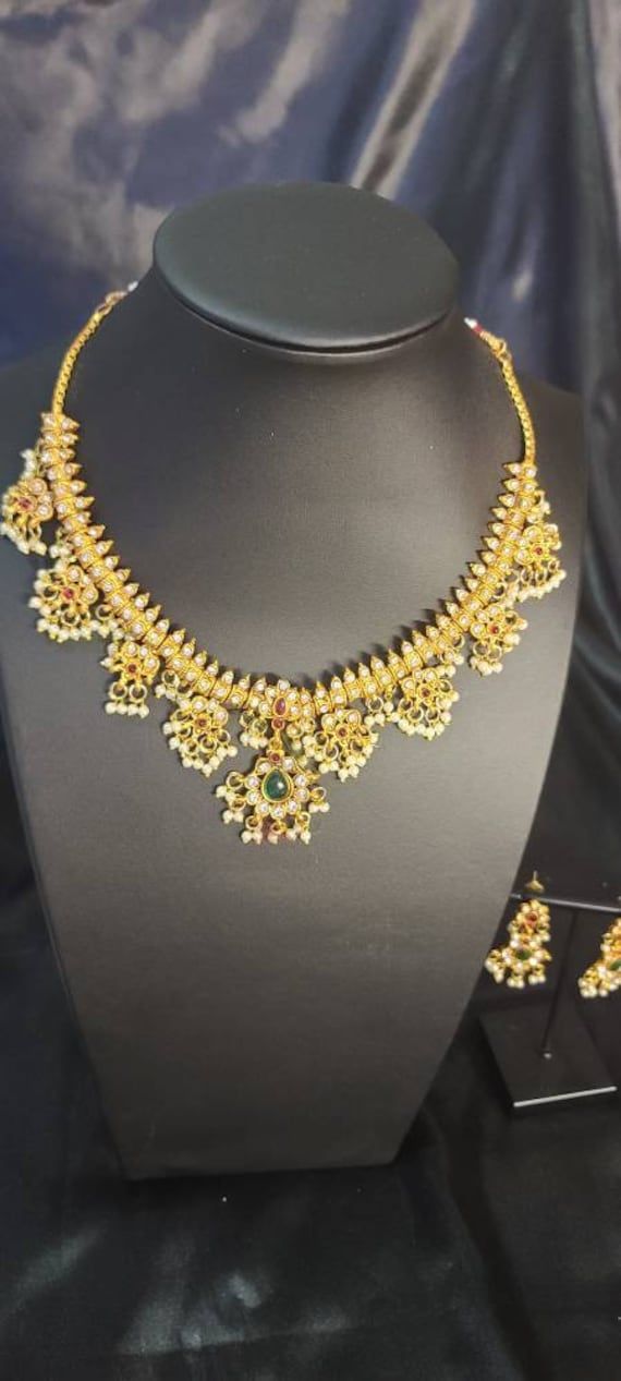 Traditional Pearl Necklace Set for Women will complement any Indian attire. Women Love Jewelry as it not only enhances their beauty, but also gives them the social confidence. Make your moment memorable with this jewel set that features a unique one of a kind traditional embellish. Dimension: 8 inch Yellow Gold Kundan Necklace For Puja, Heavy 22k Gold Kundan Necklace For Puja, 22k Gold Chandbali Bridal Necklace With Zari Work, Traditional 22k Gold Jewelry Sets For Puja, 22k Gold Bridal Necklace With Zari Chandbali, Ceremonial Temple Jewelry Sets With Latkans, Festive Temple Jewelry Bridal Sets With Latkans, 22k Gold Bridal Necklace With Zari Work For Wedding, Festive Bridal Sets With Latkans In Temple Jewelry Style