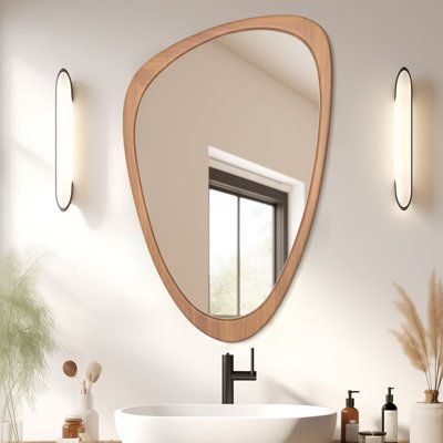 These hanging asymmetrical wall mirrors are designed to catch the eye and add a charming vibe to your home. The curvy shape and genuine pine wood frame add a natural energy reminiscent of stones you would find on a river or rocky shores. These wall mirrors provide the inviting energy of nature without clashing with modern décor pieces. The attractive shape catches the eyes of your guests while adding visual space and light to the room! The natural wood frame is made from genuine pine, featuring sturdy finger joints for a long-lasting visual style. These mirrors are lightweight, easy to hang, and feature premium shatter-resistant glass that provides a distortion-free reflection. Perfectly at home with most decor styles like midcentury modern, boho, or contemporary interior design. The size Mirrors In Bathroom, Scandinavian Mirror, Midcentury Modern Boho, Frame Mirrors, Asymmetrical Mirror, Asymmetrical Wall, Wood Framed Mirror, Visual Style, Wood Accent