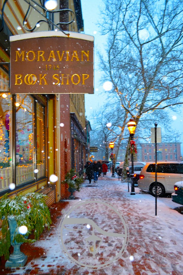 the sidewalk is covered in snow as cars are parked on the side of the street