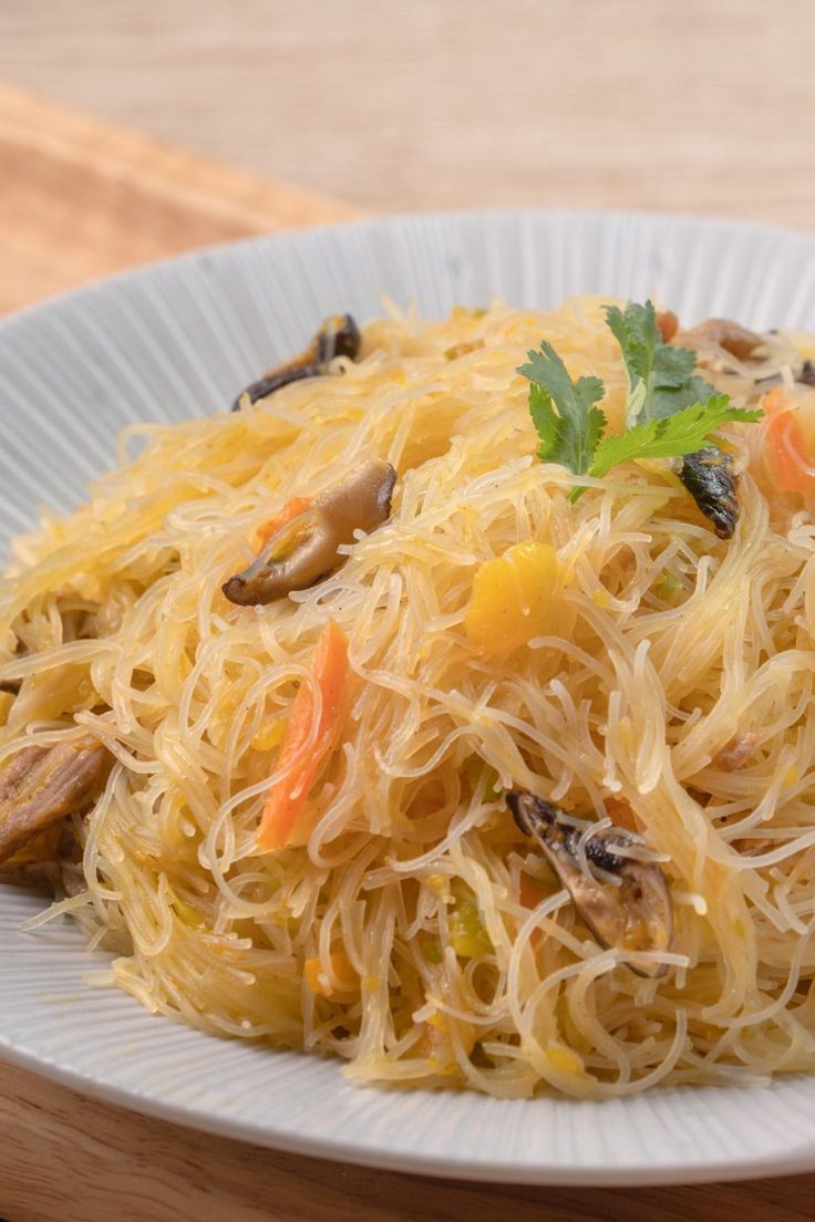 a white plate topped with pasta and mushrooms