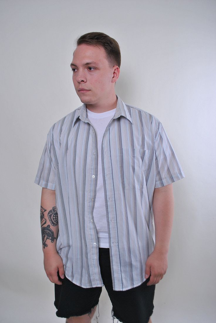 "Vintage blue striped oversized summer short sleeve shirt, Size XL Welcome to TARASCOMMON.ETSY.COM Unique clothing from the 20th century. Model tall - 175cm XL. Sleeve - 12cm / 4.72inch; ( armpit to end of sleeve); Width - 51cm / 20.07inch; Length - 81cm / 31.88inch. All measurements are taken seam to seam while lying flat. This item is vintage, so it can have some defects. Additional photos can be send We are glad that you are interested in lots that we sell. Wish you a good shopping! FOLLOW US Casual Short Sleeve T-shirt With Vertical Stripes, Casual Collared Short Sleeve Shirt With Vertical Stripes, Casual Short Sleeve Shirt With Vertical Stripes, Pinstripe Cotton Short Sleeve Shirt, Relaxed Fit Shirt With Vertical Stripes And Short Sleeves, Blue Shirt With Horizontal Stripes For Summer, Relaxed Fit Shirt With Vertical Stripes, Relaxed Fit Short Sleeve Shirt With Vertical Stripes, Vertical Stripes Relaxed Fit Short Sleeve Shirt