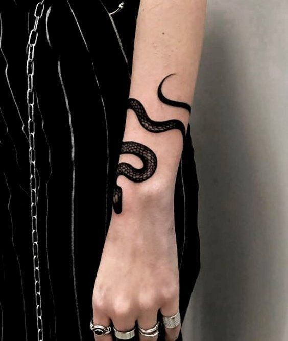 a woman's arm with a tattoo on it and a snake on the wrist