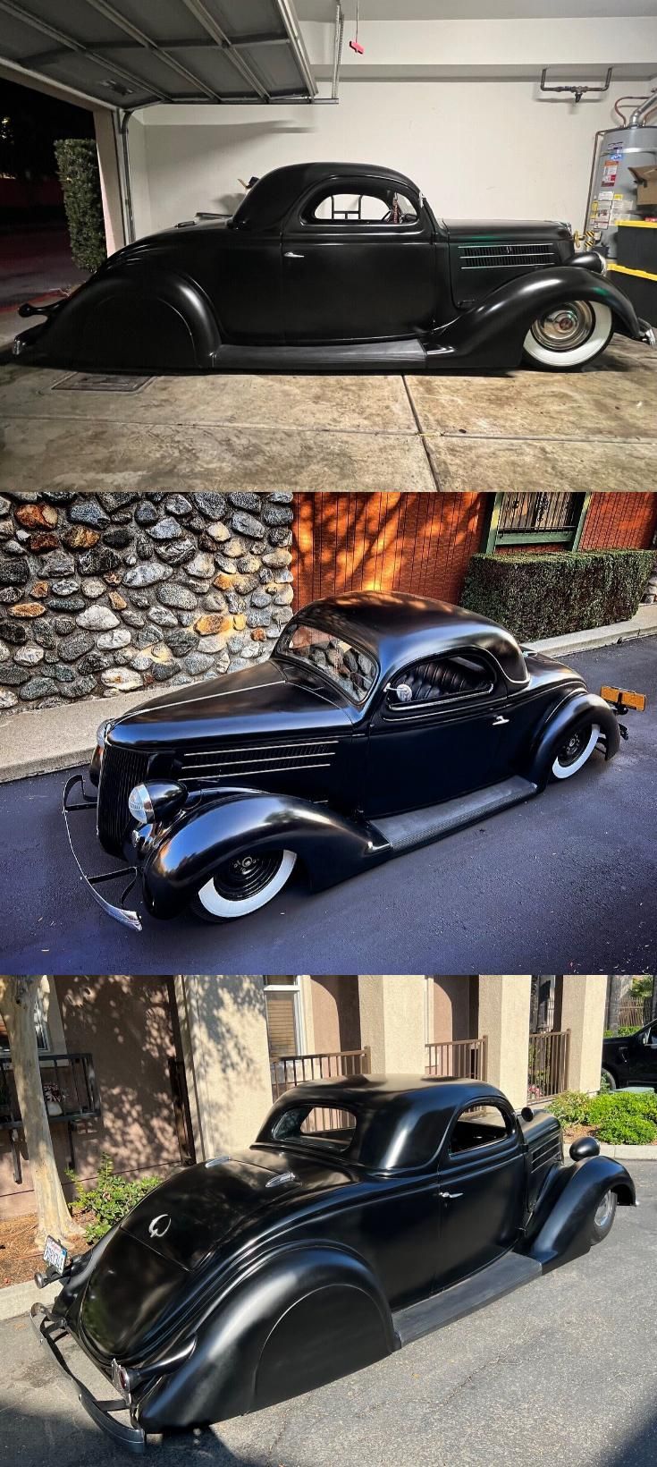 an old black car parked in front of a garage