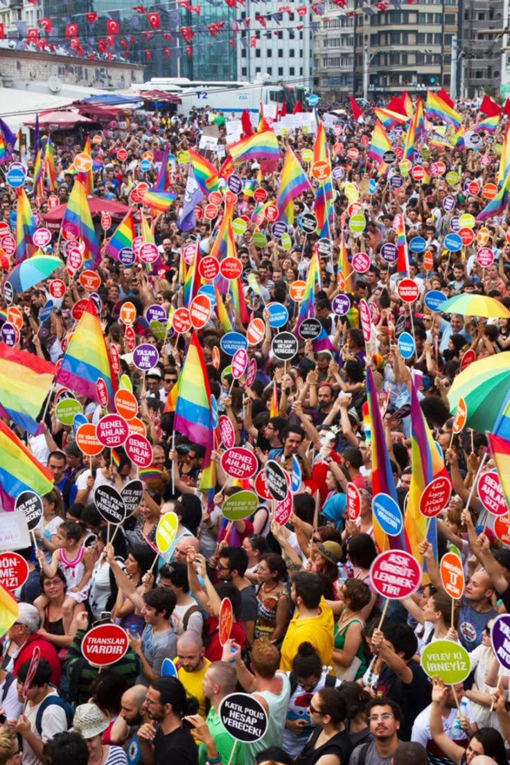 a large group of people holding up signs and umbrellas