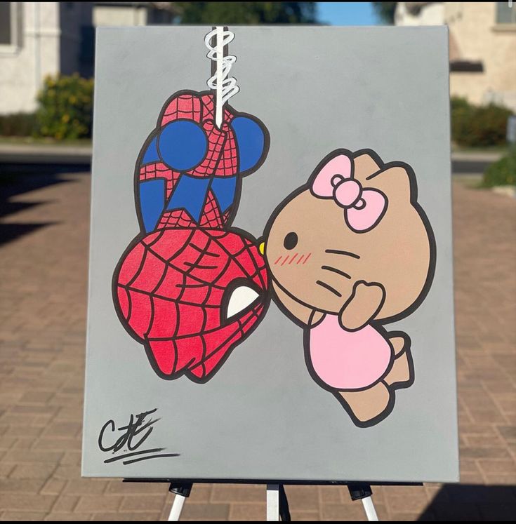 a hello kitty and spiderman painting on a easel