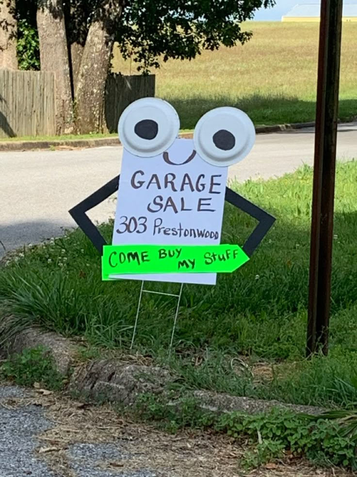 a sign that says garage sale next to a street with an eyeball on it